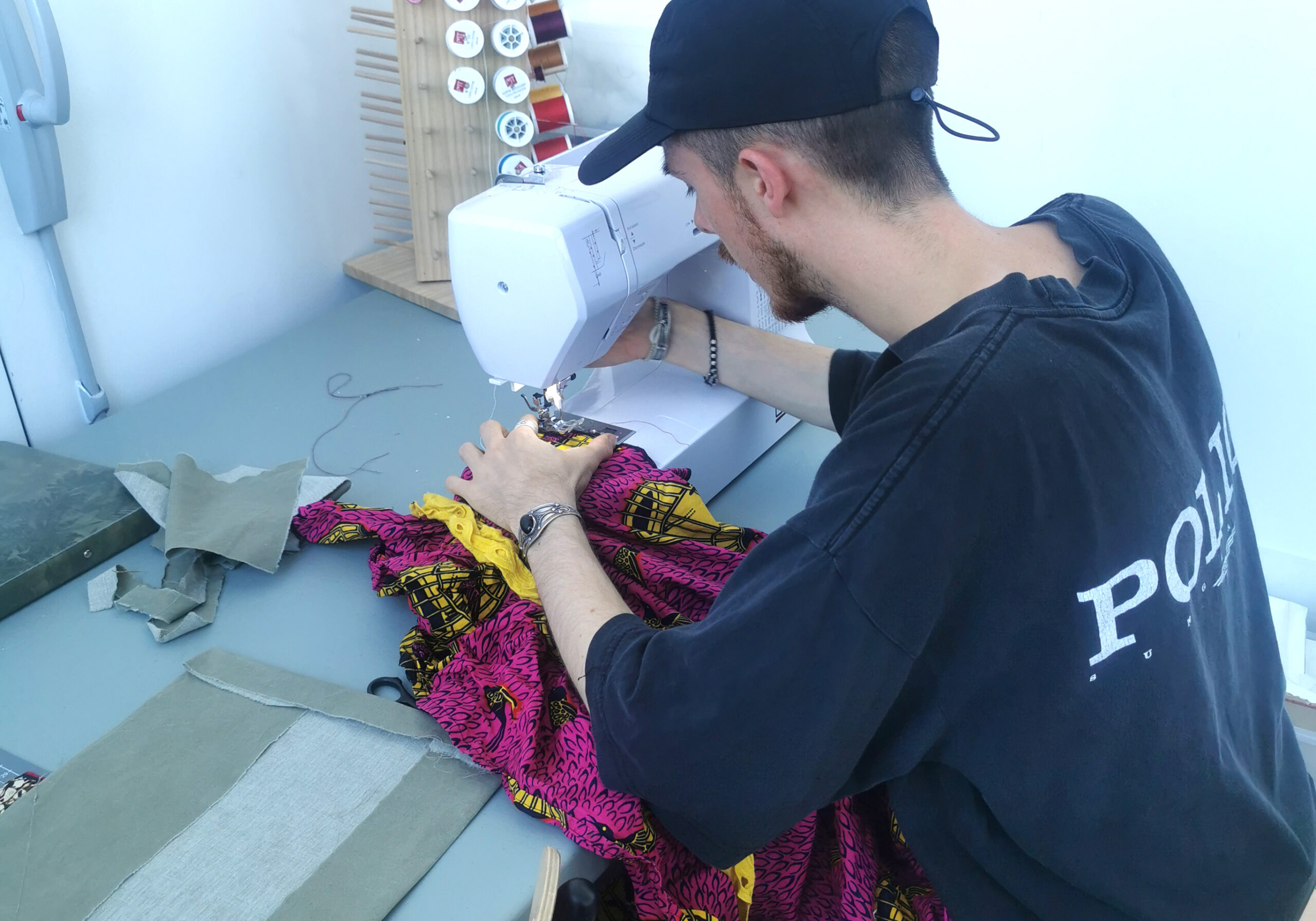 Homme qui fait de la couture lors d'un chantier d'insertion